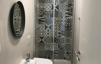 a bathroom with a shower with a sink and a mirror at Casa Turquesa in Salema