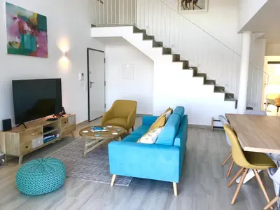 a living room with a blue couch and a tv at Casa Turquesa in Salema