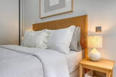 a bedroom with a bed with white pillows and a table at Seashell, a Home in Madeira in Machico
