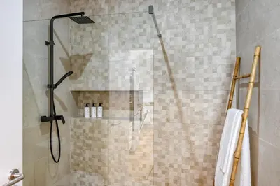 a bathroom with a shower with a glass door at Seashell, a Home in Madeira in Machico