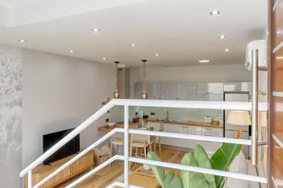 a kitchen and dining room with white walls and wood floors at Seashell, a Home in Madeira in Machico