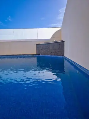 a swimming pool with blue water in a building at Basilio's Villa in Funchal