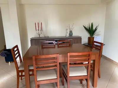 a dining room table with four chairs and candles at Guest House Santinhos in Estreito da Calheta