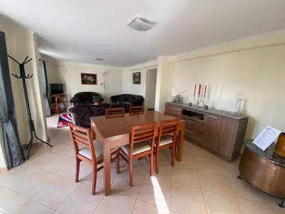 a living room with a wooden table and chairs at Guest House Santinhos in Estreito da Calheta