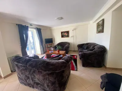 a living room with two couches and a table at Guest House Santinhos in Estreito da Calheta