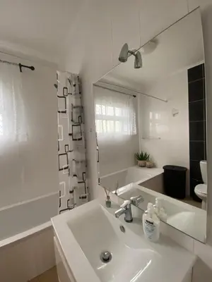 a white bathroom with a sink and a mirror at Guest House Santinhos in Estreito da Calheta