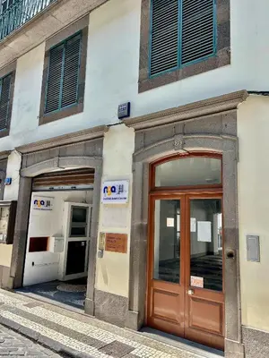 a building with a wooden door on a street at Apartment Minorca in Funchal