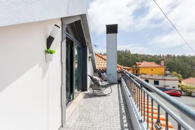 a balcony with a chair and a view of a city at Dona Maria - Tronco da Serra in Campanário