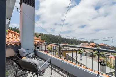 a balcony with chairs and a view of a street at Dona Maria - Tronco da Serra in Campanário