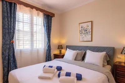 a bedroom with a large bed with blue curtains at Casa sol nascente do Caniçal in Caniçal