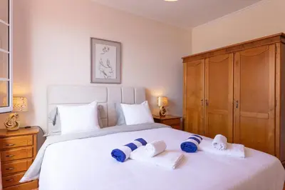 a bedroom with a white bed with blue towels on it at Casa sol nascente do Caniçal in Caniçal