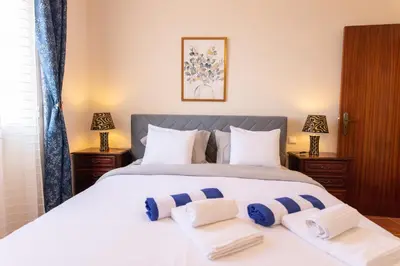 a bedroom with a large white bed with blue and white pillows at Casa sol nascente do Caniçal in Caniçal