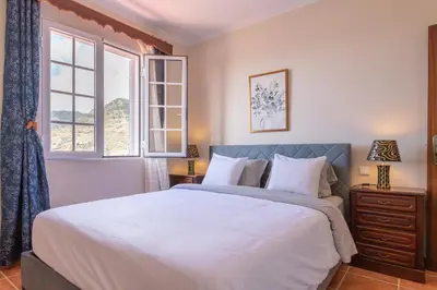 a bedroom with a large bed and a window at Casa sol nascente do Caniçal in Caniçal