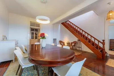 a dining room with a wooden table and white chairs at FLH Funchal Casa do Carvalhal in Funchal