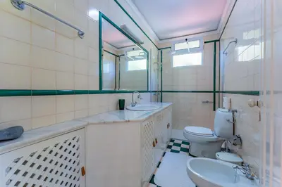 a bathroom with a toilet and a sink and a mirror at FLH Funchal Casa do Carvalhal in Funchal