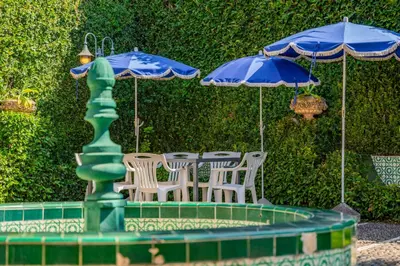 a table and chairs with umbrellas next to a fountain at FLH Funchal Casa do Carvalhal in Funchal
