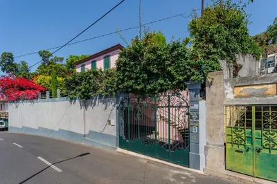 a fence with a green gate on a street at FLH Funchal Casa do Carvalhal in Funchal