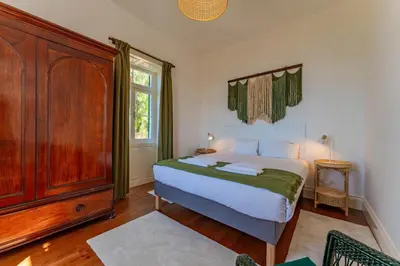 a bedroom with a bed and a wooden cabinet at FLH Funchal Casa do Carvalhal in Funchal
