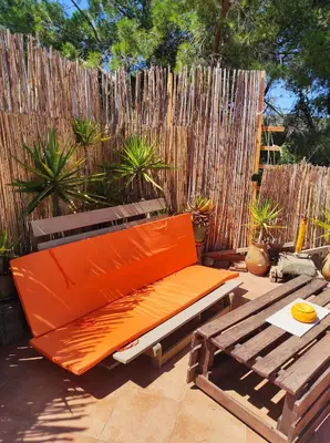 an orange bench sitting on a patio next to a fence at Casa da Cabana in Budens
