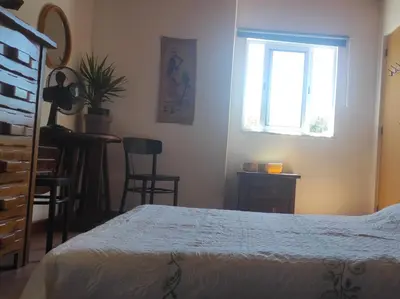 a bedroom with a bed and a window and a table at Casa da Cabana in Budens