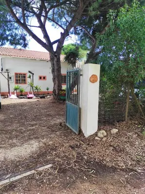 a gate in front of a house with a tree at Casa da Cabana in Budens