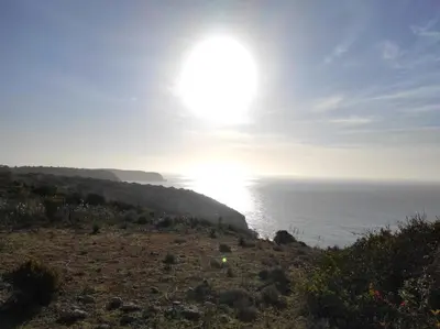 a sun setting over the ocean on a hill at Casa da Cabana in Budens