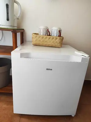 a white cabinet with two cups and a basket on it at Casa da Cabana in Budens