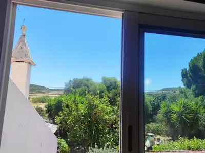 a window with a view of a church at Casa da Cabana in Budens