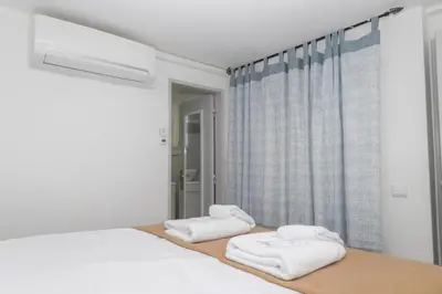 a white bedroom with two towels on a bed at Apartamentos Jorge Águas - 1Bedroom Private terrace & Sea view in Burgau