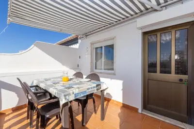 a dining room with a table and chairs at Apartamentos Jorge Águas - 1Bedroom Private terrace & Sea view in Burgau