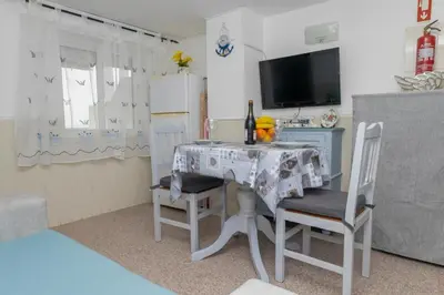 a room with a table with two chairs and a television at Apartamentos Jorge Águas - 1Bedroom Private terrace & Sea view in Burgau