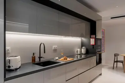 a kitchen with white cabinets and a sink with a toaster at Luxury Garden Apartment at Savoy Insular in Funchal