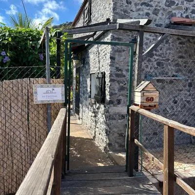 an open door to a stone building with a sign at As Casinhas da Madeira - Cosy Stone Cottage in a subtropical garden in Arco da Calheta