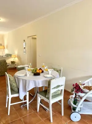 a dining room with a white table and chairs at Casa da Palmeira Porto Santo in Vila Baleira