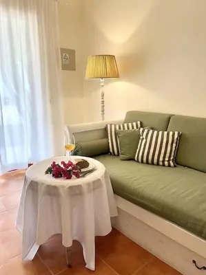 a living room with a green couch with a table at Casa da Palmeira Porto Santo in Vila Baleira