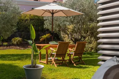 a table and two chairs and an umbrella at Savoy Residence Casa Branca III by An Island Apart in Funchal