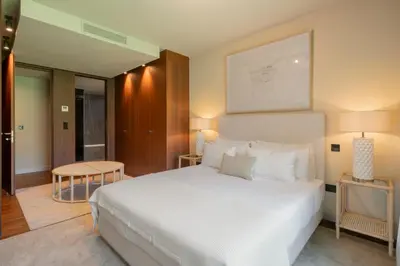 a bedroom with a large white bed and a table at Savoy Residence Casa Branca III by An Island Apart in Funchal