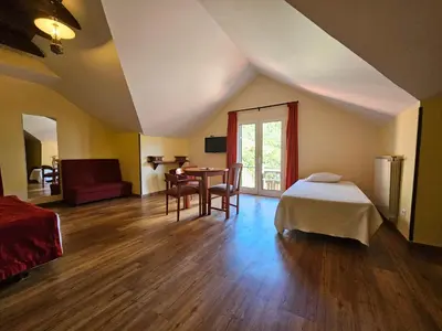 a bedroom with a bed and a table and chairs at Valley View Hotel Encumeada in Senhora do Rosário