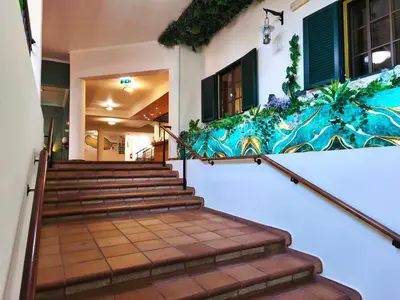 a set of stairs in a building with a painting on the wall at Valley View Hotel Encumeada in Senhora do Rosário