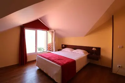 a bedroom with a large bed and a window at Valley View Hotel Encumeada in Senhora do Rosário