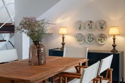 a dining room with a table and plates on the wall at Casa Amarela da Fajã da Areia by An Island Apart in São Vicente