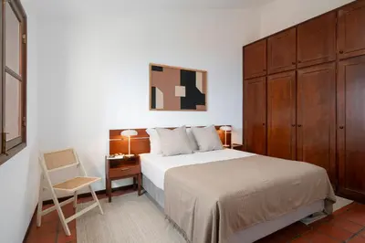 a bedroom with a bed and a chair and a desk at Casa Amarela da Fajã da Areia by An Island Apart in São Vicente
