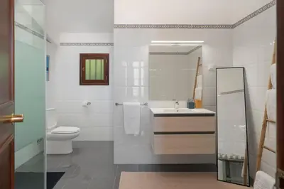 a bathroom with a toilet and a sink and a mirror at Casa Amarela da Fajã da Areia by An Island Apart in São Vicente