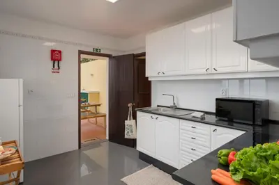 a kitchen with white cabinets and a counter top at Casa Amarela da Fajã da Areia by An Island Apart in São Vicente