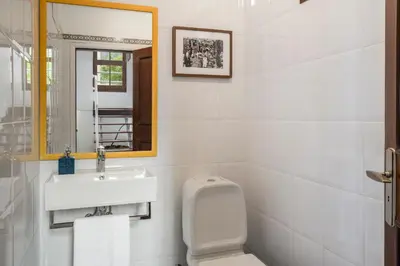 a bathroom with a sink and a toilet and a mirror at Casa Amarela da Fajã da Areia by An Island Apart in São Vicente