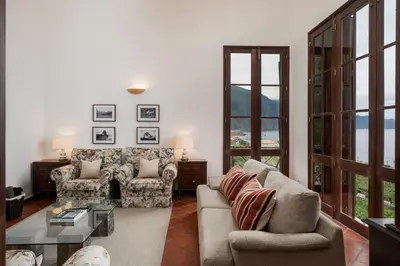 a living room with two couches and a table at Casa Amarela da Fajã da Areia by An Island Apart in São Vicente