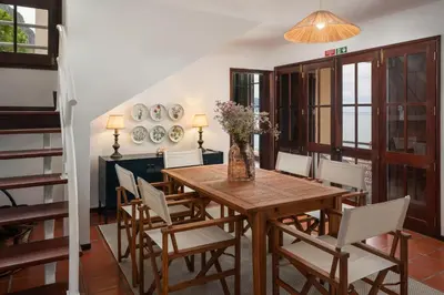 a dining room with a wooden table and chairs at Casa Amarela da Fajã da Areia by An Island Apart in São Vicente