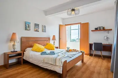 a bedroom with a large bed with yellow pillows at Tornos in Funchal