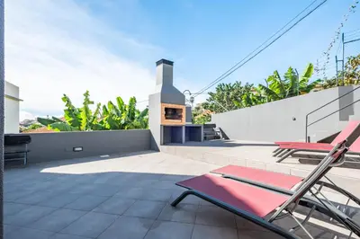 a patio with two chairs and a fireplace on a house at Tornos in Funchal