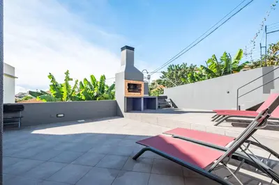 a patio with two chairs and a fireplace on a house at Tornos in Funchal